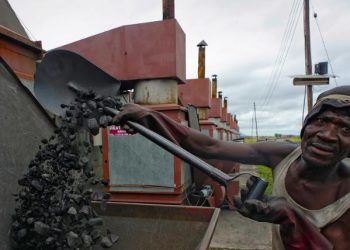 Trabalhador no Malawi enche uma caldeira com carvão em uma empresa de tabaco: estudo considera 19 fatores de risco no trabalho, incluindo jornadas muito longas e exposição à poluição do ar - Foto: OIT/Marcelo Crozet