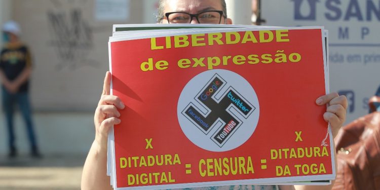 Mulher carrega cartaz com símbolo nazista em manifestação pró-bolsonaro em Campinas. Fotos: Leandro Ferreira / Hora Campinas