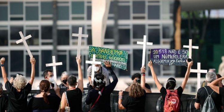 Manifestantes carregam faixas antigovernistas e cruzes simbolizando as 600 mil mortes Foto: Pedro França/Agência Senado