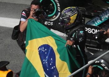 O piloto Lewis Hamilton carrega bandeira brasileira ao final da corrido em São Paulo. Foto: Agência Brasil