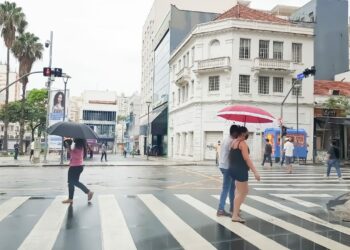 Pedestres caminham no Centro de Campinas protegidos por sombrinhas e guarda-chuvas: encontros de Réveillon deverão ser feitos em áreas cobertas Foto: Leandro Ferreira/Hora Campinas
