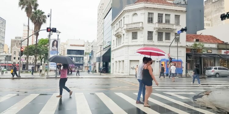 Pedestres caminham no Centro de Campinas protegidos por sombrinhas e guarda-chuvas: encontros de Réveillon deverão ser feitos em áreas cobertas Foto: Leandro Ferreira/Hora Campinas