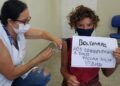 O menino Daniel foi ao CS Vila Ipê tomar a vacina e mandou um recado para o presidente Bolsonaro Foto: Leandro Ferreira/Hora Campinas