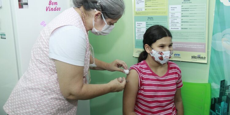 Enfermeira aplica vacina contra o coronavírus em criança em unidade de Jaguariúna: mobilização Foto: Ivair Oliveira/PMJ/Divulgação