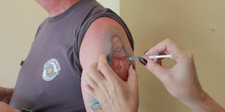 Na campanha de vacinação no quartel da PM, a tatuagem revela-se por inteiro, mostrando que a fé sustenta nos momentos de adversidades Foto: Leandro Ferreira/Hora Campinas