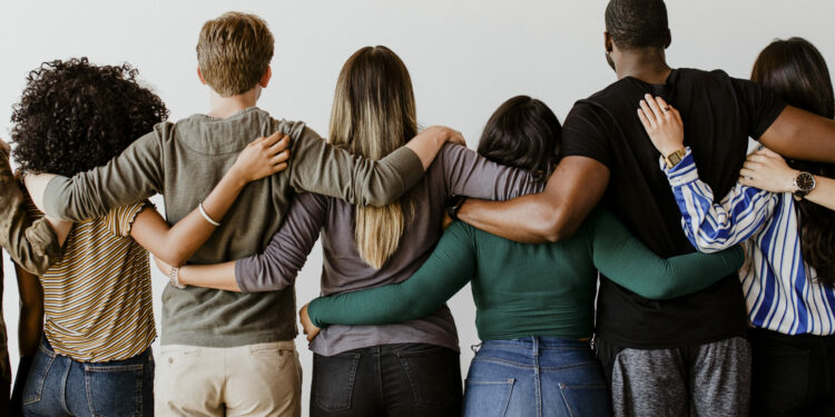 Rearview of diverse people hugging each other