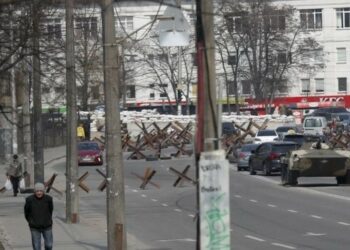 Carros e civis circulam por entre veículos militares e barricadas em Kiev. suspensos. Foto: Agência Lusa