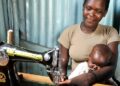 Mulher cuida do filho enquanto trabalha como costureira, no Quênia. Foto: Marcel Crozet/ONU