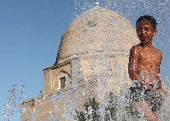 Menino de 11 anos no Uzbequistão refresca-se da onda de calor. Foto: Unicef