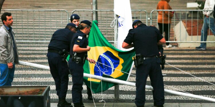 Membros da Guarda Municipal preparam a bandeira brasileira para a cerimônia de hasteamento antes do desfile desta quarta-feira, na Avenida Francisco Glicério Foto: Leandro Ferreira/Hora Campinas