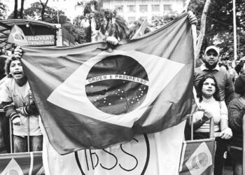 Ativistas empunham bandeira e faixas no ato de protesto na Avenida Francisco Glicério, sob chuva: defesa da democracia, apoio a Lula e contra Bolsonaro Foto: Giuliana Teixeira/Divulgação