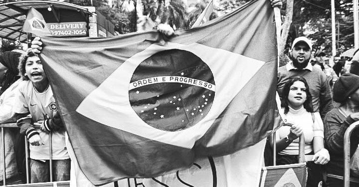 Ativistas empunham bandeira e faixas no ato de protesto na Avenida Francisco Glicério, sob chuva: defesa da democracia, apoio a Lula e contra Bolsonaro Foto: Giuliana Teixeira/Divulgação