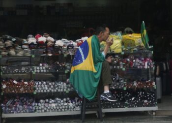 Na Avenida Francisco Glicério, Centro de Campinas, homem com a bandeira do Brasil divaga em pensamentos Foto: Leandro Ferreira/Hora Campinas