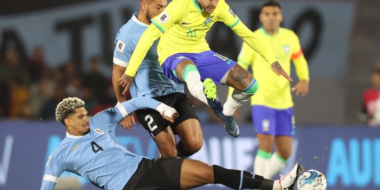 Neymar salta para escapar de falta no jogo entre Uruguai x Brasil no Estadio Centenário, em Montevidéu, pelas Eliminatórias Sul-Americanas - Foto: Vitor Silva/CBF/Divulgação