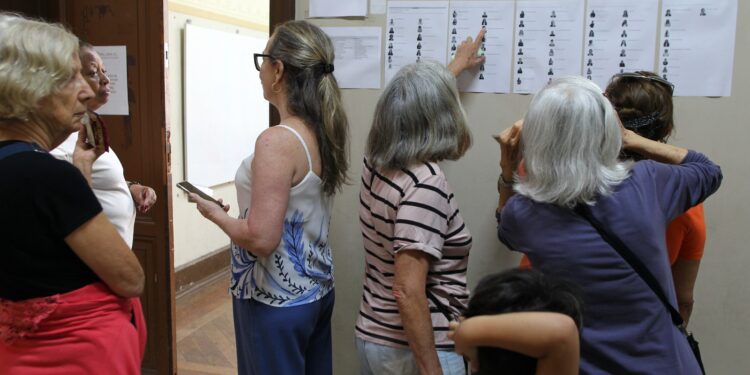 Eleitores observam lista dos 71 candidatos afixada no prédio da Escola Carlos Gomes - Foto: Leandro Ferreira/Hora Campinas