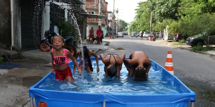 Crianças conquistam um espaço improvisado no meio da rua para se refrescarem. Foto: Tânia Rêgo/Agência Brasil