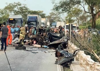 Bombeiros, brigadistas e equipes de imprensa próximo aos destroços do ônibus após a colisão na BR-116 - Foto: Corpo de Bombeiros de MG/Divulgação