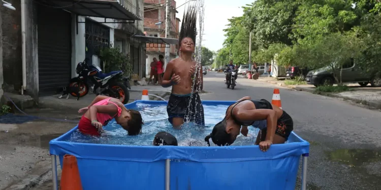 Crianças se refrescam em piscina de plástico: calor intenso Foto: Tânia Rêgo/Agência Brasil