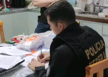 Policial federal analisa documentos na casa dos suspeitos em Vinhedo: prisão de pai e filho - Foto: Divulgação PF
