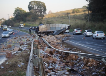 Carreta com produtos de limpeza tomba e motorista fica entre as ferragens